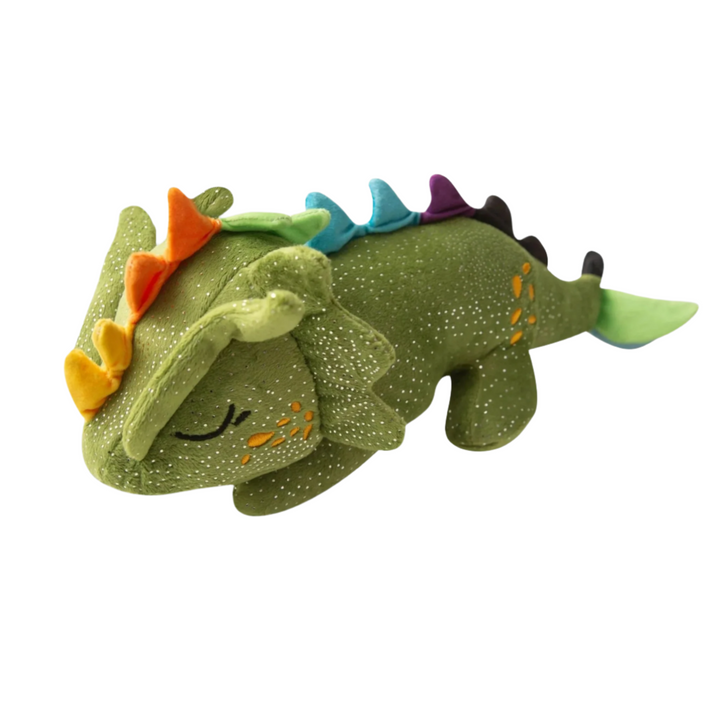 Plush green dinosaur toy with colorful spikes and a smiling face placed on a white wooden surface.