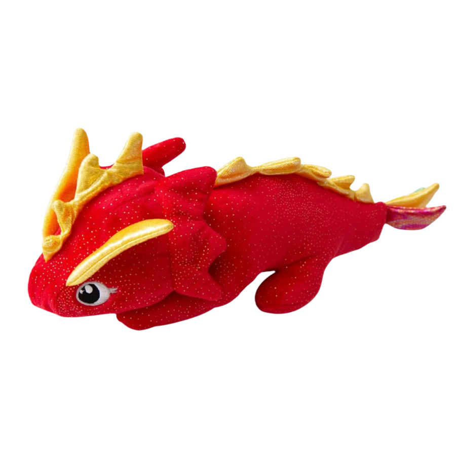 Vibrant red dragon plush dog toy with yellow spikes, resting on a white wooden surface