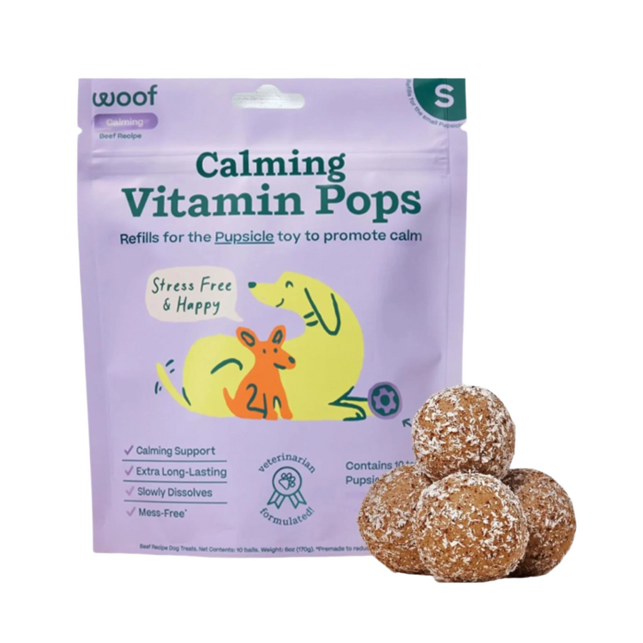 Calming vitamin pops for small dogs from the Woof dog wellness brand, featuring a package with colorful illustrations and the calming pops visible on a white background.